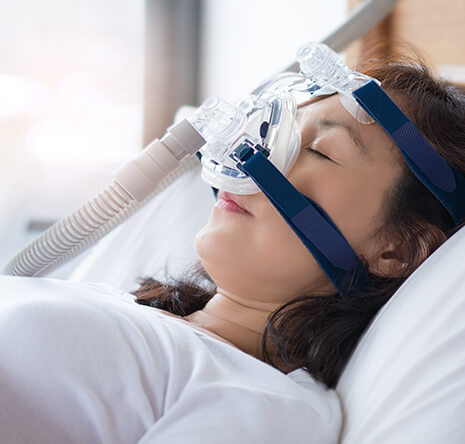 sleeping woman wearing a CPAP mask